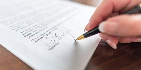 A person signing an important legal document A person signing an important legal document