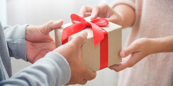 a person handing a gift to someone else. 