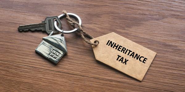 a bundle with a key, a key ring of a metal house and wooden key ring with the words 'INHERITANCE TAX' 