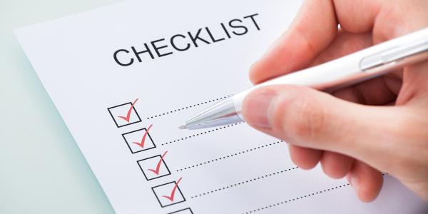 a piece of white paper titled 'CHECKLIST' down the left side are boxes with a red tick in each one. a piece of white paper titled 'CHECKLIST' down the left side are boxes with a red tick in each one.