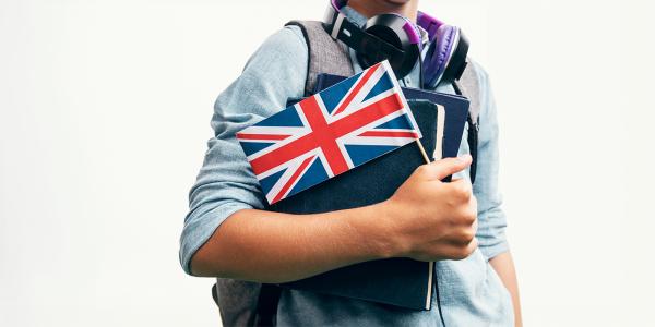 a student carrying books and a flag of the United Kingdom