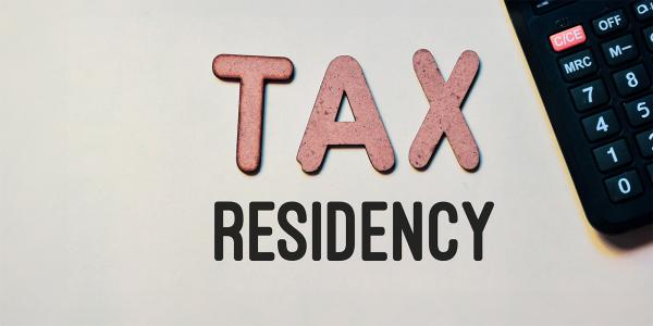 the word 'TAX' in red letters and the word 'RESIDENCY' in black letters next to a calculator