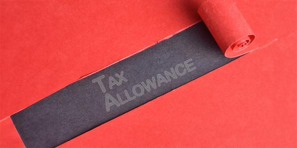 red material with a section peeled back to reveal a black background with the words 'TAX ALLOWANCE' written in grey text