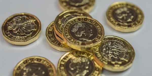 pound coins scattered against a white background. 