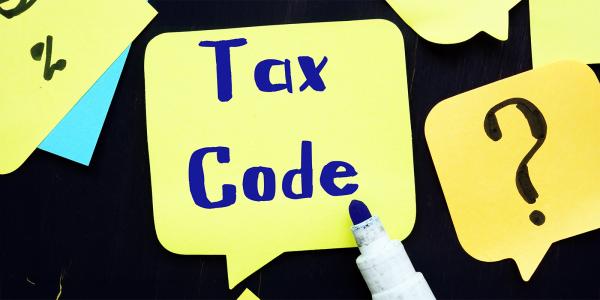 a yellow speech bubbles and post it notes on a black background inside the largest speech bubble are the words 'TAX CODE' a yellow speech bubbles and post it notes on a black background inside the largest speech bubble are the words 'TAX CODE'