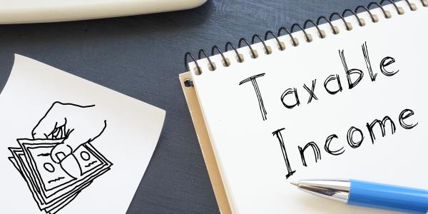 a drawing of a person holding money and a pad of paper with the words 'TAXABLE INCOME' written on it. a drawing of a person holding money and a pad of paper with the words 'TAXABLE INCOME' written on it.