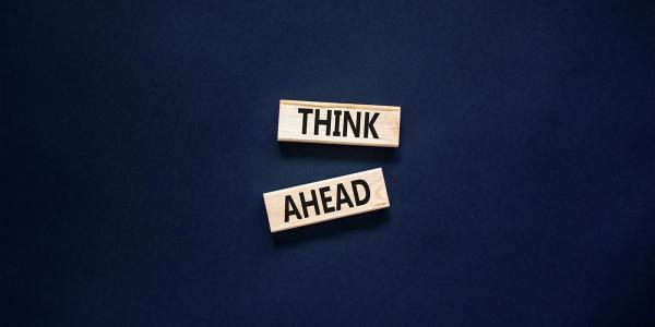 A dark coloured background with 2 wooden blocks, each block has a word written on it, together this reads 'THINK AHEAD' A dark coloured background with 2 wooden blocks, each block has a word written on it, together this reads 'THINK AHEAD'