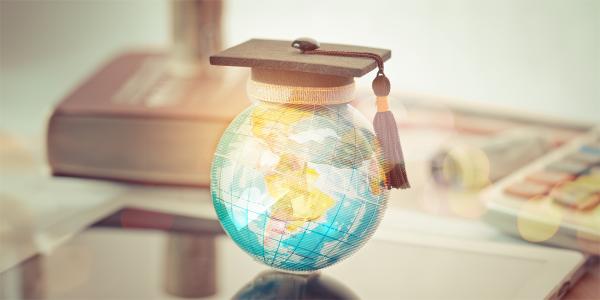 a little world globe wearing a tiny graduation cap.
