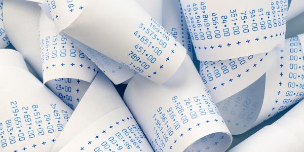 a bundle of calculations on receipt paper. 