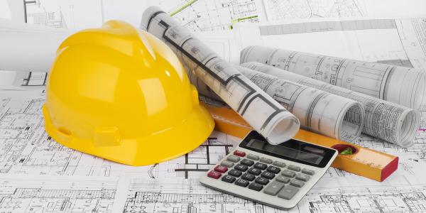 background is made up of construction drawings, on top of those sit a construction hat, rolled up plans, a calculator and a spirit level. background is made up of construction drawings, on top of those sit a construction hat, rolled up plans, a calculator and a spirit level.