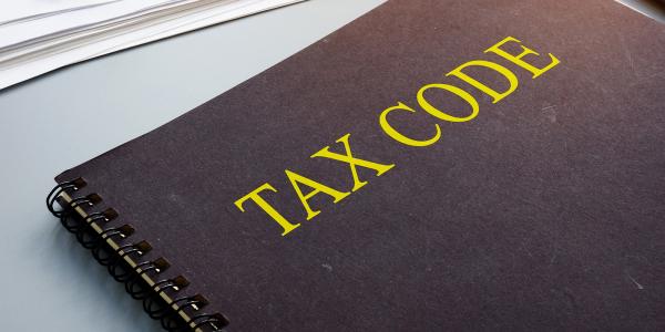 a thick book with the words 'TAX CODE' on the cover. a thick book with the words 'TAX CODE' on the cover.