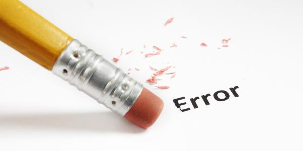 the word 'ERROR' written on a sheet of paper, with a pencil eraser rubbing it out. 