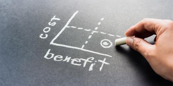 a graph drawn on a chalkboard, one side stating 'BENEFITS' the other stating 'COST' 