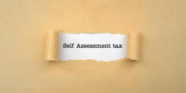 brown paper with a tear in the centre, through the tear you can see a white background with the words 'SELF ASSESSMENT TAX' in black text brown paper with a tear in the centre, through the tear you can see a white background with the words 'SELF ASSESSMENT TAX' in black text