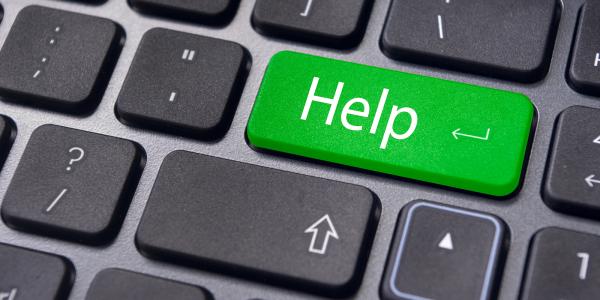 A keyboard with a green coloured key with the word 'HELP' typed on it in white text. A keyboard with a green coloured key with the word 'HELP' typed on it in white text.