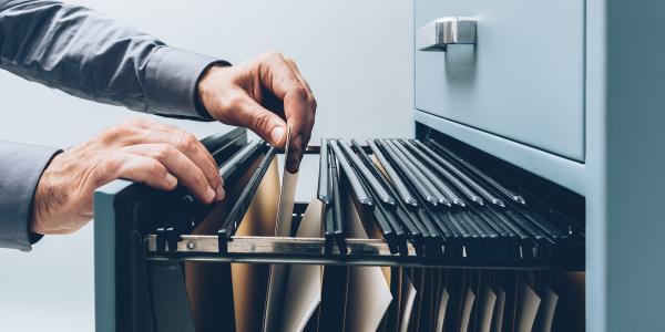 a person looking through a filing cabinet