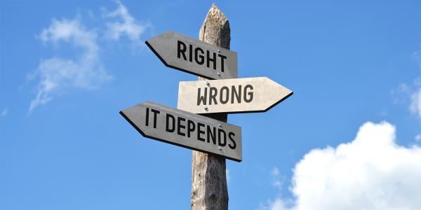 a wooden street sign with arrows pointing in different directions, the signs read 'RIGHT', 'WRONG' and 'IT DEPENDS'