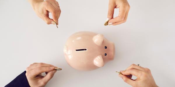 a piggy bank with four people putting coins inside a piggy bank with four people putting coins inside