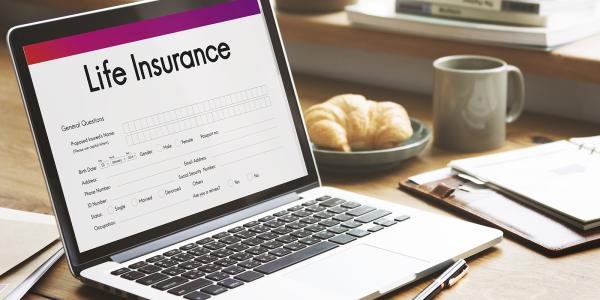 a laptop with a screen loaded up showing a form to fill in with the words 'LIFE INSURANCE' at the top. a laptop with a screen loaded up showing a form to fill in with the words 'LIFE INSURANCE' at the top.