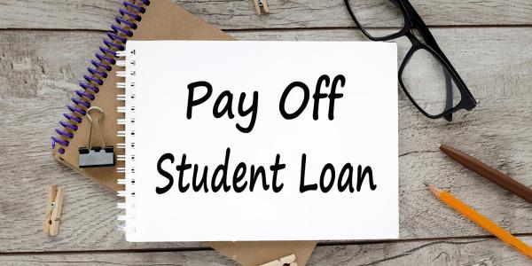 a notebook with the words 'PAY OFF STUDENT LOAN' written on it in black ink a notebook with the words 'PAY OFF STUDENT LOAN' written on it in black ink