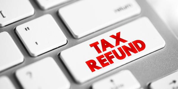 a computer keyboard, one key has red text that reads 'TAX REFUND' a computer keyboard, one key has red text that reads 'TAX REFUND'