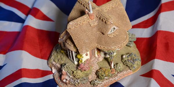background is the UK flag, on top of this is a model of a traditional English cottage background is the UK flag, on top of this is a model of a traditional English cottage