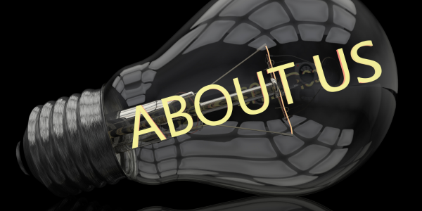 A black background with a lightbulb visible, across the lightbulb the words 'ABOUT US' can be seen in yellow text. A black background with a lightbulb visible, across the lightbulb the words 'ABOUT US' can be seen in yellow text.