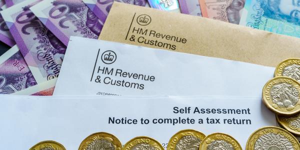 A letter from HMRC with the words 'SELF ASSESSMENT NOTICE TO COMPLETE A TAX RETURN' on the top, surrounded by British currency A letter from HMRC with the words 'SELF ASSESSMENT NOTICE TO COMPLETE A TAX RETURN' on the top, surrounded by British currency