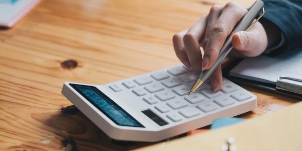 A person typing on a calculator A person typing on a calculator