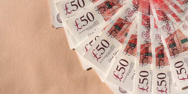 a spread of British £50 notes against a brown background a spread of British £50 notes against a brown background
