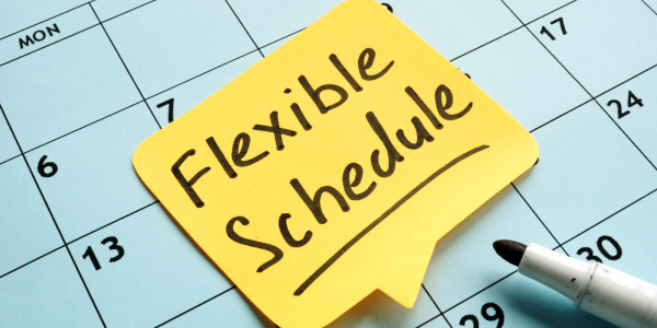 A calendar with a yellow post-it note, the note reads 'FLEXIBLE SCHEDULE' in black ink. A calendar with a yellow post-it note, the note reads 'FLEXIBLE SCHEDULE' in black ink.