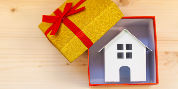 A gift box containing a small model house. A gift box containing a small model house.