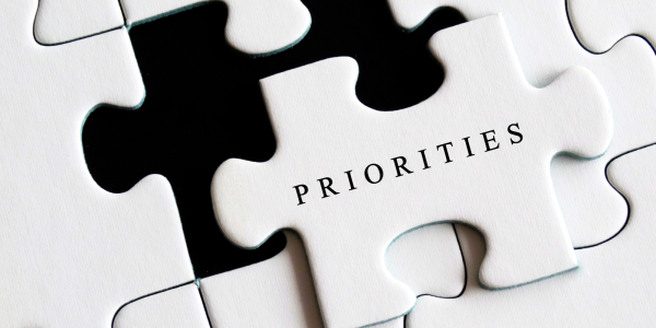 a white jigsaw, the one missing piece has the word 'PRIORITIES' on it in black text. a white jigsaw, the one missing piece has the word 'PRIORITIES' on it in black text.