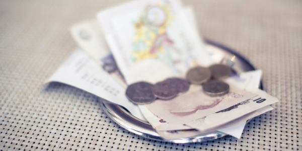 a silver plate containing a receipt and cash. a silver plate containing a receipt and cash.