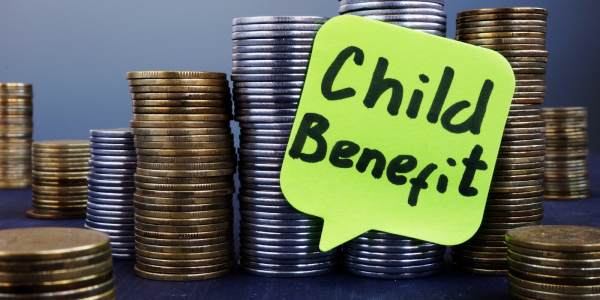 Many stacks of coins with a yellow speech bubble that reads 'CHILD BENEFIT'. Many stacks of coins with a yellow speech bubble that reads 'CHILD BENEFIT'.