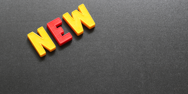 Grey background with plastic letters spelling the word 'NEW' Grey background with plastic letters spelling the word 'NEW'