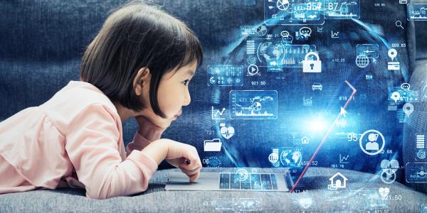 A small child laid down looking on a laptop, holograms can be seen where the laptop screen is, the hologram is of a sphere with lots of various icons. A small child laid down looking on a laptop, holograms can be seen where the laptop screen is, the hologram is of a sphere with lots of various icons.