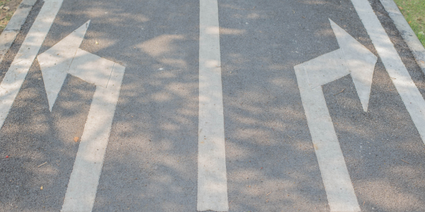 A road with lines and arrows one pointing left and one pointing right. A road with lines and arrows one pointing left and one pointing right.