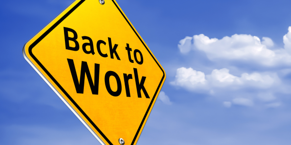 Yellow traffic sign with the words 'BACK TO WORK' in black text against a background of the blue sky. Yellow traffic sign with the words 'BACK TO WORK' in black text against a background of the blue sky.