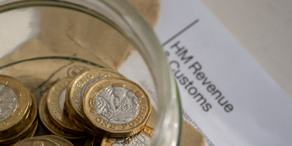 A letter from HMRC along with a glass jar of coins. A letter from HMRC along with a glass jar of coins.