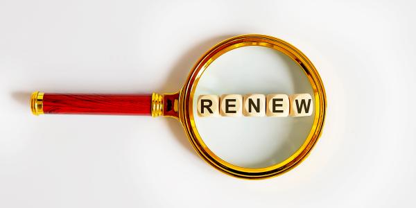 A magnifying glass hovering over some wooden blocks, the wooden blocks read the word 'RENEW'. A magnifying glass hovering over some wooden blocks, the wooden blocks read the word 'RENEW'.