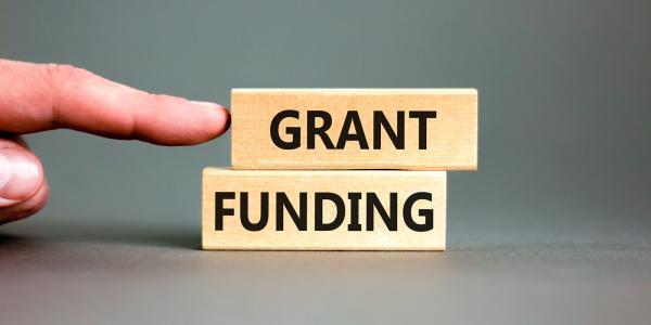 2 blocks of wood each with a word printed on it, together they read 'GRANT FUNDING'. 2 blocks of wood each with a word printed on it, together they read 'GRANT FUNDING'.