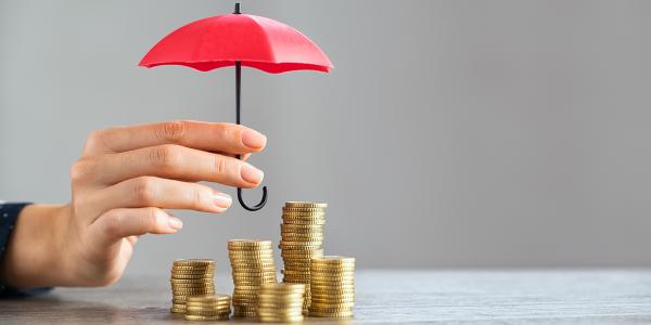 Stacks of coins with a person holding an umbrella above. Stacks of coins with a person holding an umbrella above.