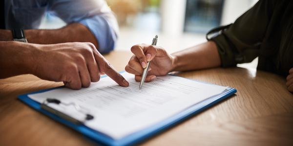 2 people filling out a form together. 2 people filling out a form together.