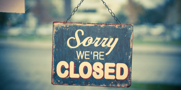 A sign hanging on a door that reads 'SORRY WE'RE CLOSED'. A sign hanging on a door that reads 'SORRY WE'RE CLOSED'.