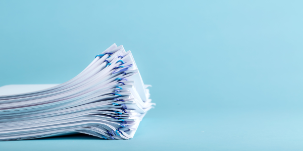 a bunch of papers clipped together against a blue background. a bunch of papers clipped together against a blue background.