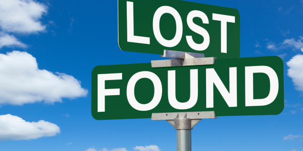 Dark green road signs with the words 'LOST' and 'FOUND' written on them in white text against a blue sky background. Dark green road signs with the words 'LOST' and 'FOUND' written on them in white text against a blue sky background.