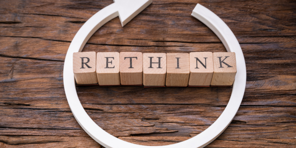 Wooden letters spelling out the word 'RETHINK' with a white circular arrow around it. Wooden letters spelling out the word 'RETHINK' with a white circular arrow around it.