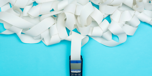 A card payment machine with a lot of paper coming out of it A card payment machine with a lot of paper coming out of it