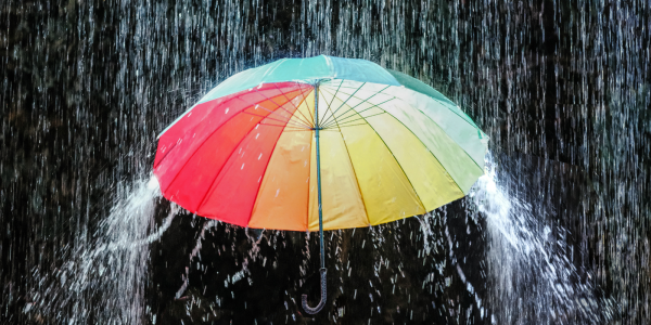 A colourful umbrella with a downpour of water A colourful umbrella with a downpour of water